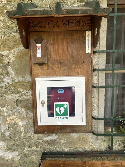 La teca del defibrillatore fissata alla bacheca in legno all’esterno della Baita Verde